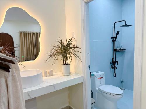 a bathroom with a sink and a toilet and a mirror at Malis Homestay in Trà Vinh