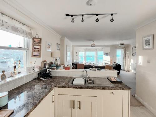 een keuken met een spoelbak en een woonkamer bij Ocean Breezes in St Ives