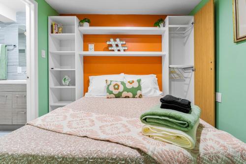 a bedroom with a bed with an orange headboard at Luxury Miami Studio Next to Beach & Airport in Miami