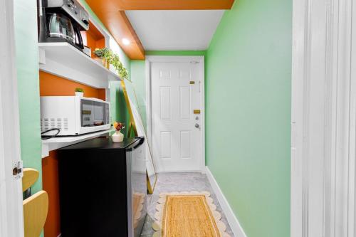 a small hallway with an orange and green wall at Luxury Miami Studio Next to Beach & Airport in Miami