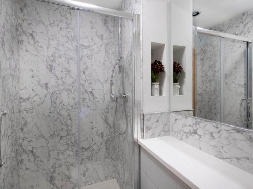 a white bathroom with a shower and a sink at Orchard Barns in North Nibley
