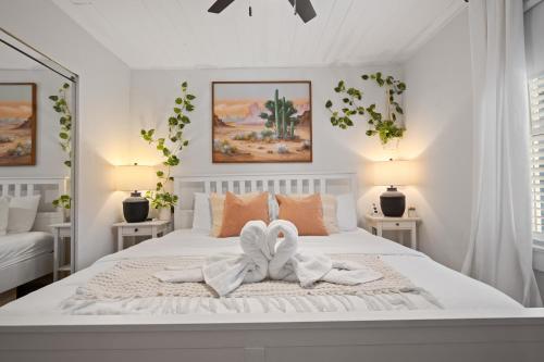 a white bedroom with a white bed with a bow on it at Entire cottage in Tampa in Tampa