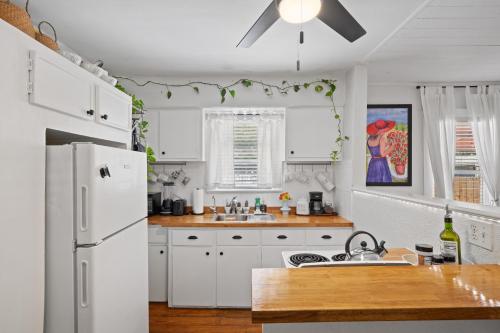 a kitchen with white cabinets and a white refrigerator at Entire cottage in Tampa in Tampa