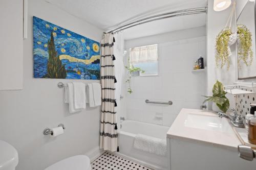 a white bathroom with a shower and a sink at Entire cottage in Tampa in Tampa