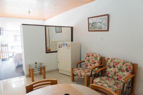 a room with a refrigerator and two chairs and a table at 100 Wonderful House in Bogotá