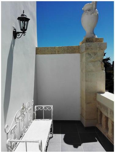 a white bench on a wall with a street light at Corte del Pascià in Lecce