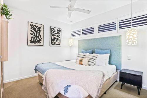 Un dormitorio con una cama y un ventilador de techo. en Reefside at 201 Lake Street, en Cairns