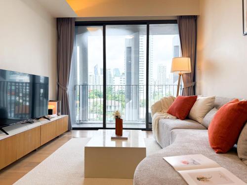 a living room with a couch and a tv at Expansive Luxury 2BR - Ultra Fast Wifi - Phrom Phong in Bang Kapi