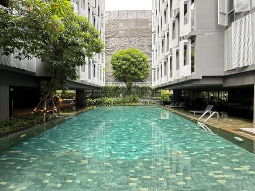 a swimming pool in the middle of a building at Expansive Luxury 2BR - Ultra Fast Wifi - Phrom Phong in Bang Kapi