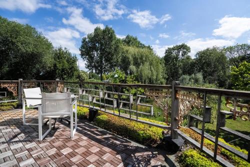 a white chair sitting on a brick patio next to a fence at Reijgershof - The Barok lounge in Amsterdam