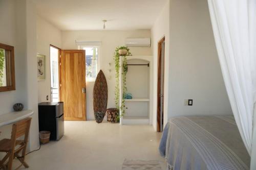a bedroom with a bed and a door to a bathroom at Nicho Suite @ Sayulita Surfside Suites in Sayulita