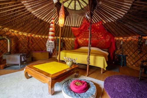 a room with a bed and a table in a yurt at Reijgershof - Yurt Experience with garden view in Amsterdam