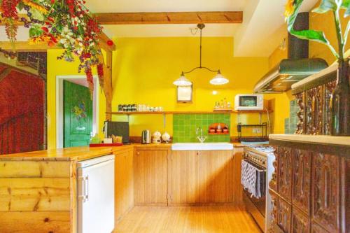 a kitchen with yellow walls and wooden cabinets at Reijgershof - Yurt Experience with garden view in Amsterdam