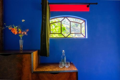 a blue room with a window with two glasses on a wooden table at Reijgershof - Yurt Experience with garden view in Amsterdam