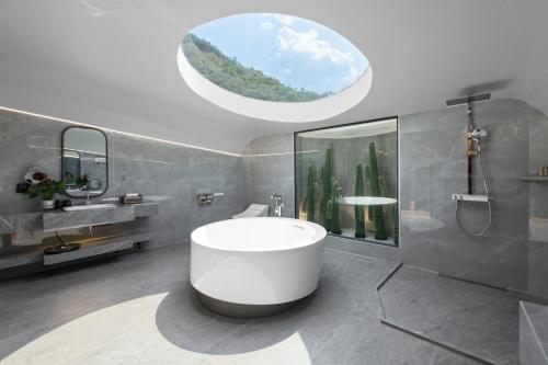 a bathroom with a tub and a sink and a window at Moc Chau Island - Bach Long Glass Bridge in Mộc Châu
