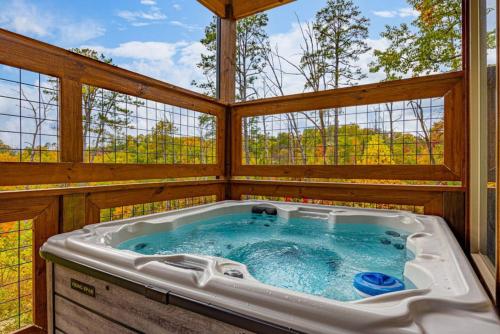 a hot tub in a house with windows at Rabbit Point Cabin in Williamsburg