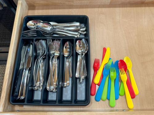 a tray with forks and spoons and utensils on a table at Rabbit Point Cabin in Williamsburg