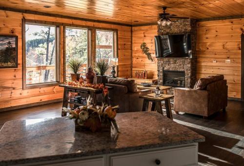 a kitchen and living room with a fireplace in a log cabin at Rabbit Point Cabin in Williamsburg
