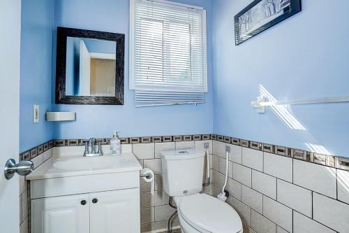 a blue bathroom with a toilet and a sink at Charming Autumn Getaway Sleeps 6 Mins to Lake in Barrie