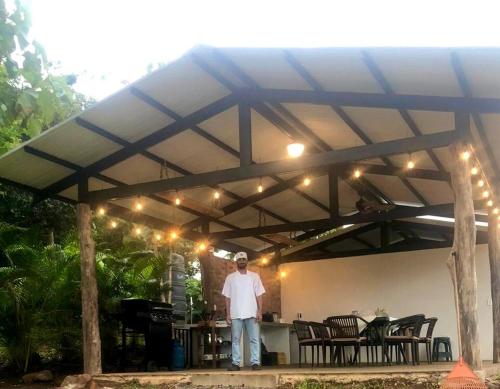 a man is standing under a patio umbrella at Luxury Villa Ceibo - Exquisite, Private, Serene in San Mateo