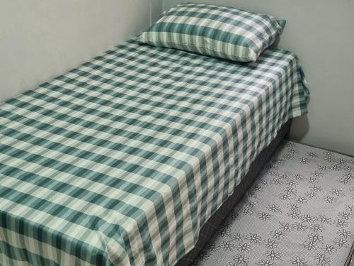 レシフェにあるApartamento em Barra de Jangadaのベッド1台(チェック入りの毛布、枕付)