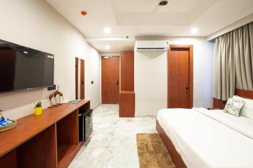 a hotel room with a bed and a television at Aarchh Regency Noida in Noida
