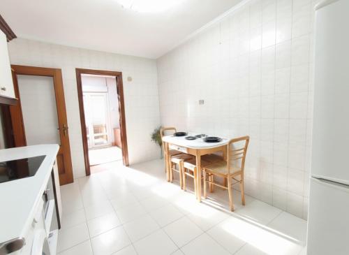 a kitchen with a table and chairs in a room at COSTA VASCA LEIOA - HoME in Leioa