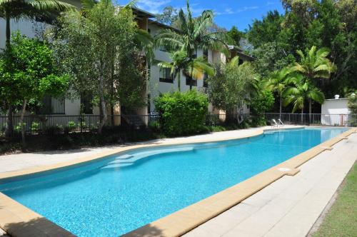 a swimming pool in front of a house at Baden 26 - Rainbow Shores - Swimming pools - Tennis court - Walk to beach in Rainbow Beach