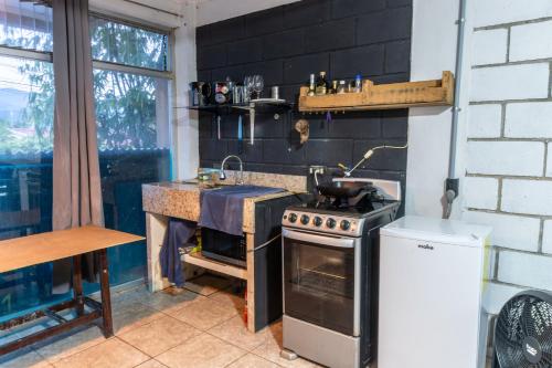 a kitchen with a stove and a sink at 31M Studio Apartment Bosques de Dona Rosa in Heredia