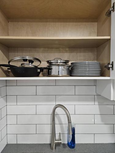 a kitchen with pots and pans on a shelf at Guest Home Near Regina Airport YQR in Regina