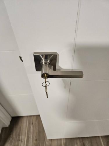 a metal flushaucet in a room with a ceiling at Guest Home Near Regina Airport YQR in Regina