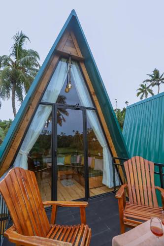 a room with two chairs and a tent at Sparrow's House in Weligama