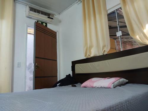 Un dormitorio con una cama y una ventana y una puerta. en Pousada vale das aguas, en Foz do Iguaçu