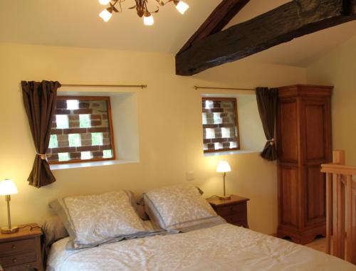 een slaapkamer met een bed en 2 ramen bij Le Pigeonnier de Lacalm GÎTE in Saint-Grégoire
