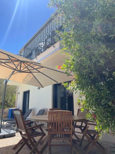 a wooden table and chairs under an umbrella at Nefeli Villas in Hersonissos