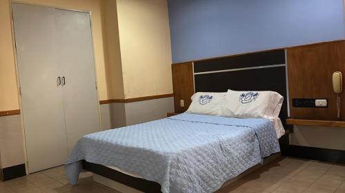 una piccola camera con letto e armadio di Hotel Cajigal Caracas a Caracas