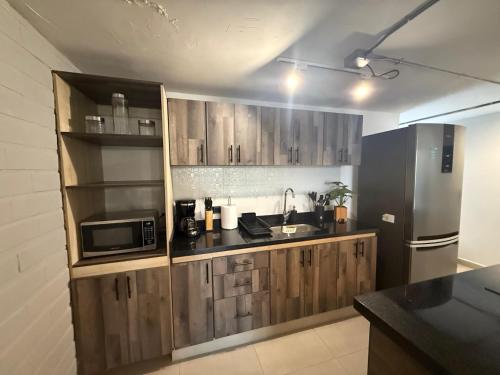 Estación El SaltoApartamento de lujo Poblado的厨房配有木制橱柜和不锈钢冰箱