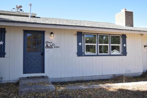 a white house with a blue door and windows at Rustic Western Home Steps from Rte 66 & Grand Canyon Train Station in Williams