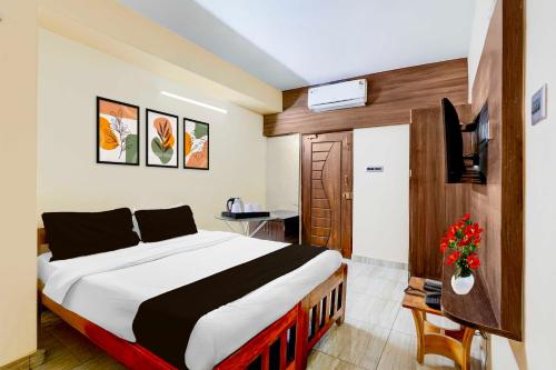 a bedroom with a large bed and a television at Hotel O Vellore Near CMC Hospital in Vellore