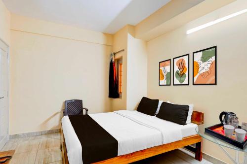 a bedroom with a bed and a table with a chair at Hotel O Vellore Near CMC Hospital in Vellore