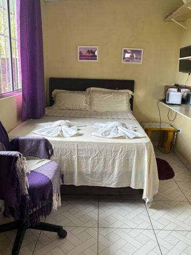 a bedroom with a bed and a chair at Studio Funcional in Guaraqueçaba