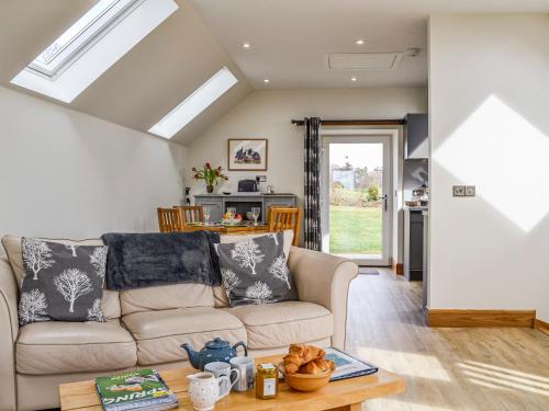 a living room with a couch and a table at The Old Mill in Fettercairn