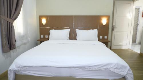 a bedroom with a large bed with white sheets and pillows at Diyar Villas Puncak R7-3 in Puncak