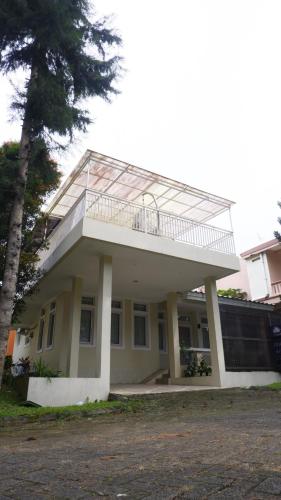 a house with a balcony on top of it at Diyar Villas Puncak R7-3 in Puncak