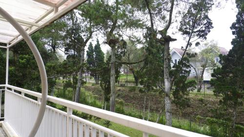 a view from the porch of a house with trees at Diyar Villas Puncak R7-3 in Puncak
