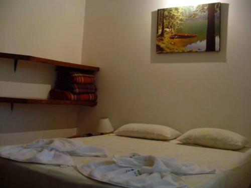 1 cama en un dormitorio con una foto en la pared en Samburá Chalés, en Ilha Comprida