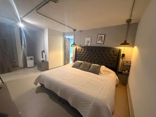 Estación El SaltoApartamento de lujo Poblado的卧室里有一张大床，床单和枕头都是白色的