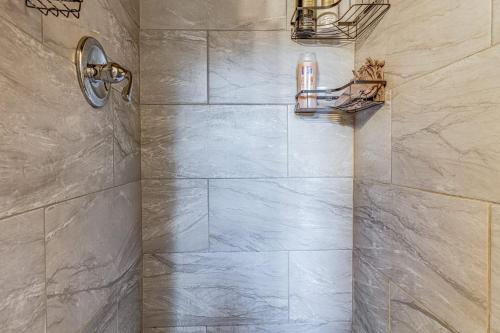 a bathroom with a shower with a stone wall at Midtown Magic Spacious Bungalow Steps From C-y in Memphis