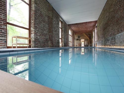 an empty swimming pool in a brick building at Group Villa with Pool & Sauna in Wanze