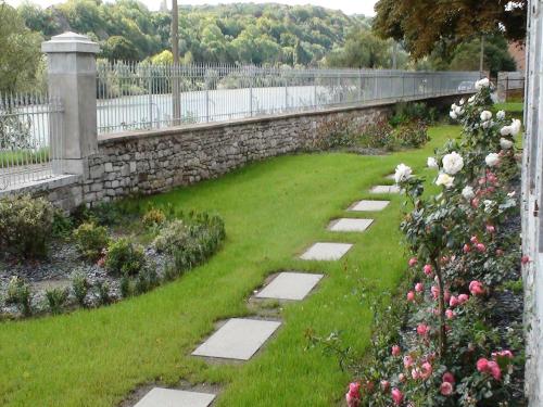 a garden with a stone wall and a stone walkway at Group Villa with Pool & Sauna in Wanze